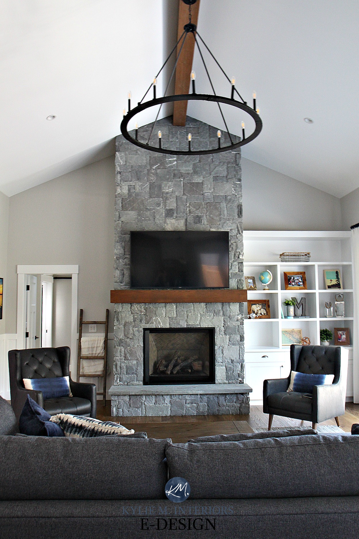 living room design with a stone fireplace and built-in shelves