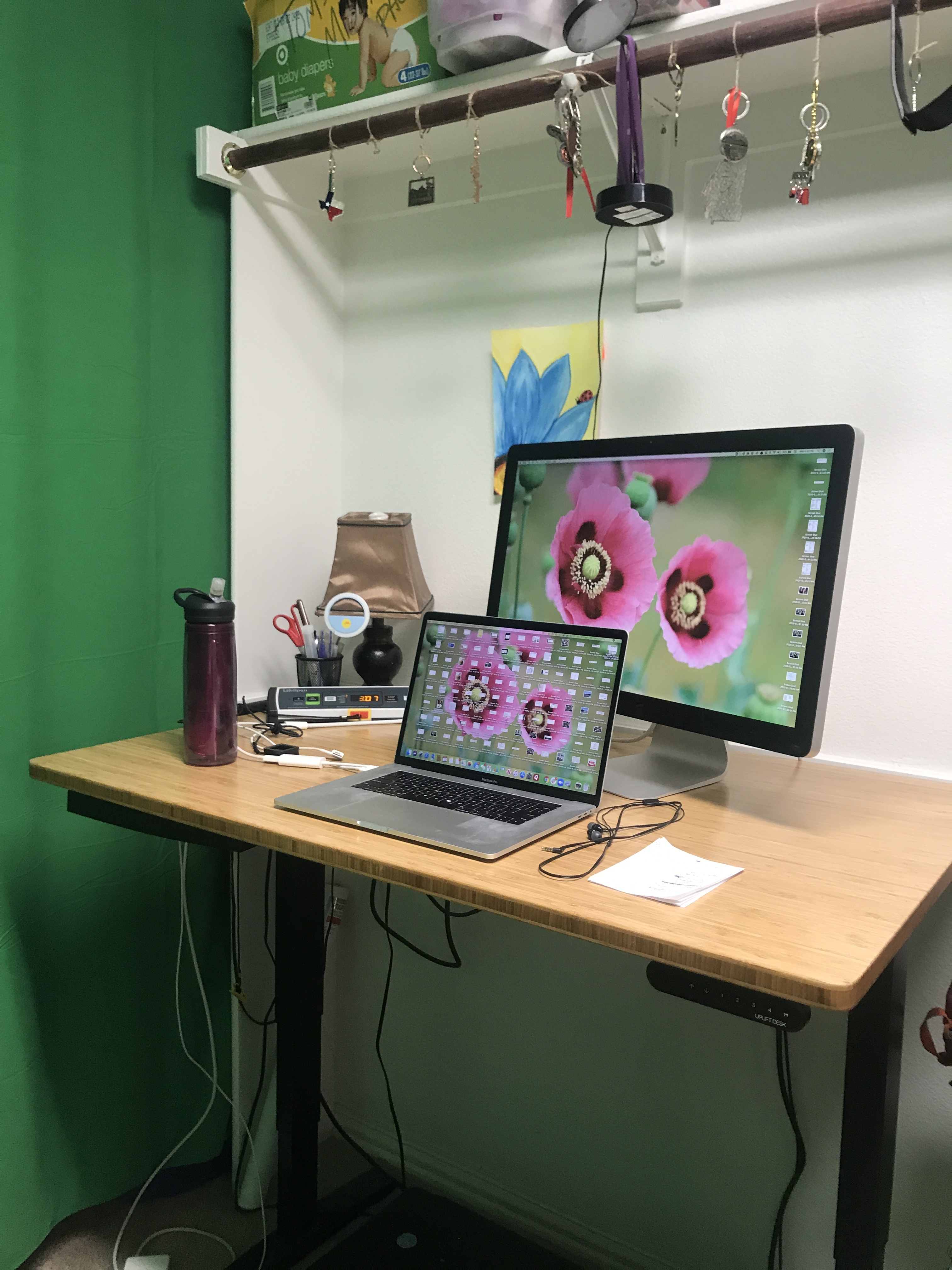 desk setup with a standing desk, laptop, and desktop