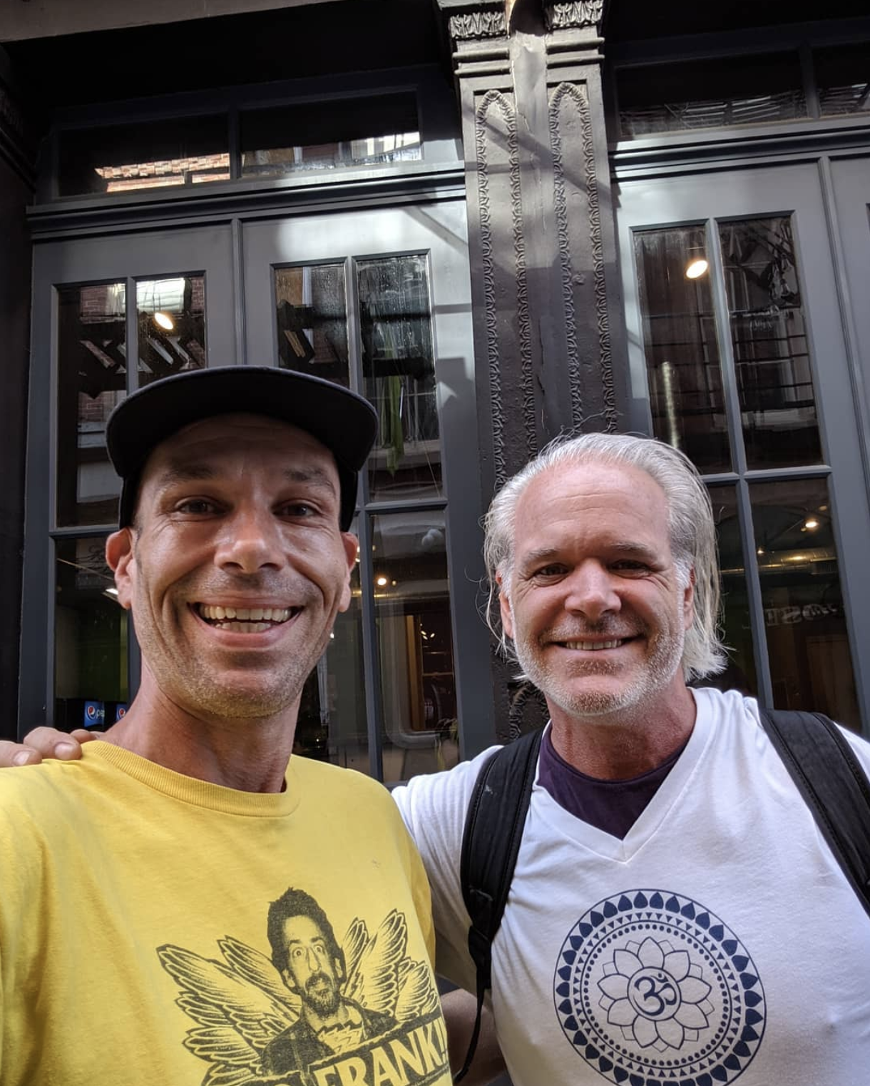 Mark Nordstrom wearing a yellow shirt and standing next to a man in a white shirt
