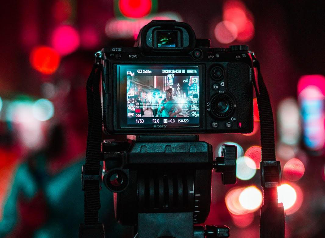 camera taking a photo of a busy, lit-up street