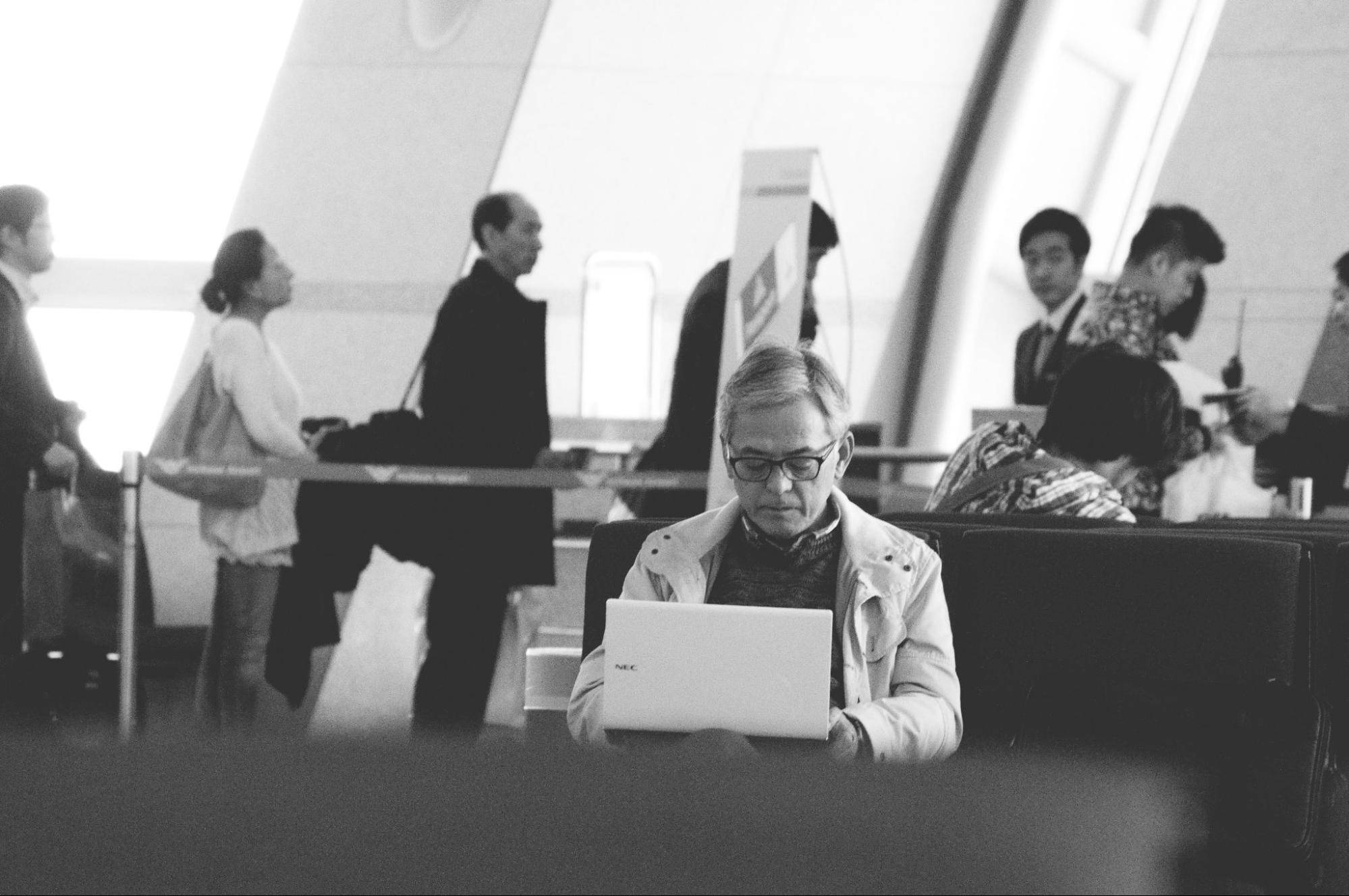 black and white image of a man working on a laptop