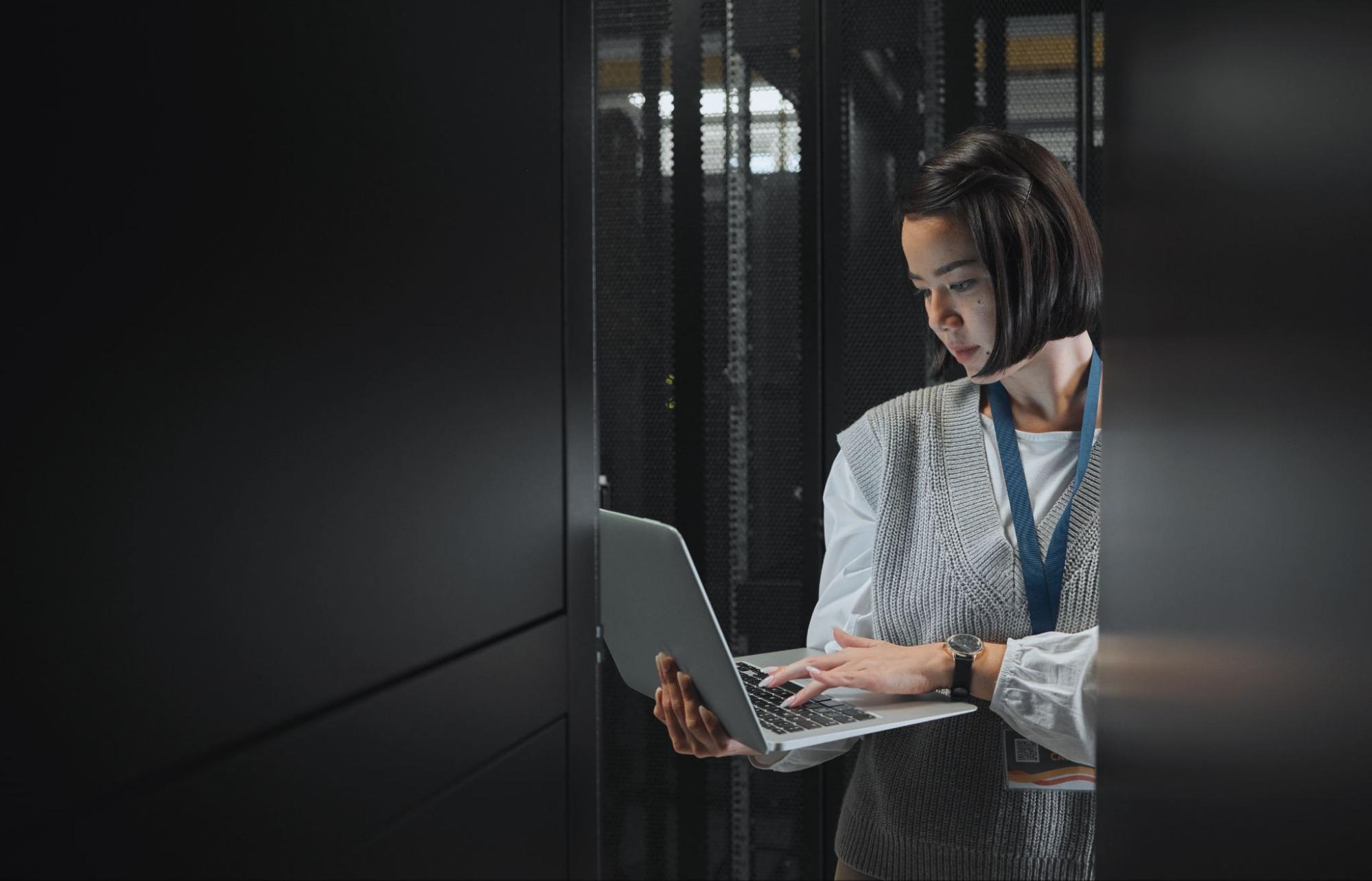 woman working on a laptop with servers