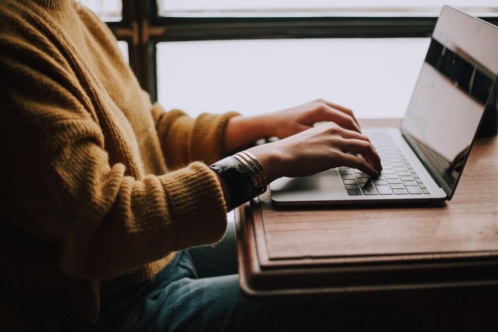 woman working at a table with a laptop