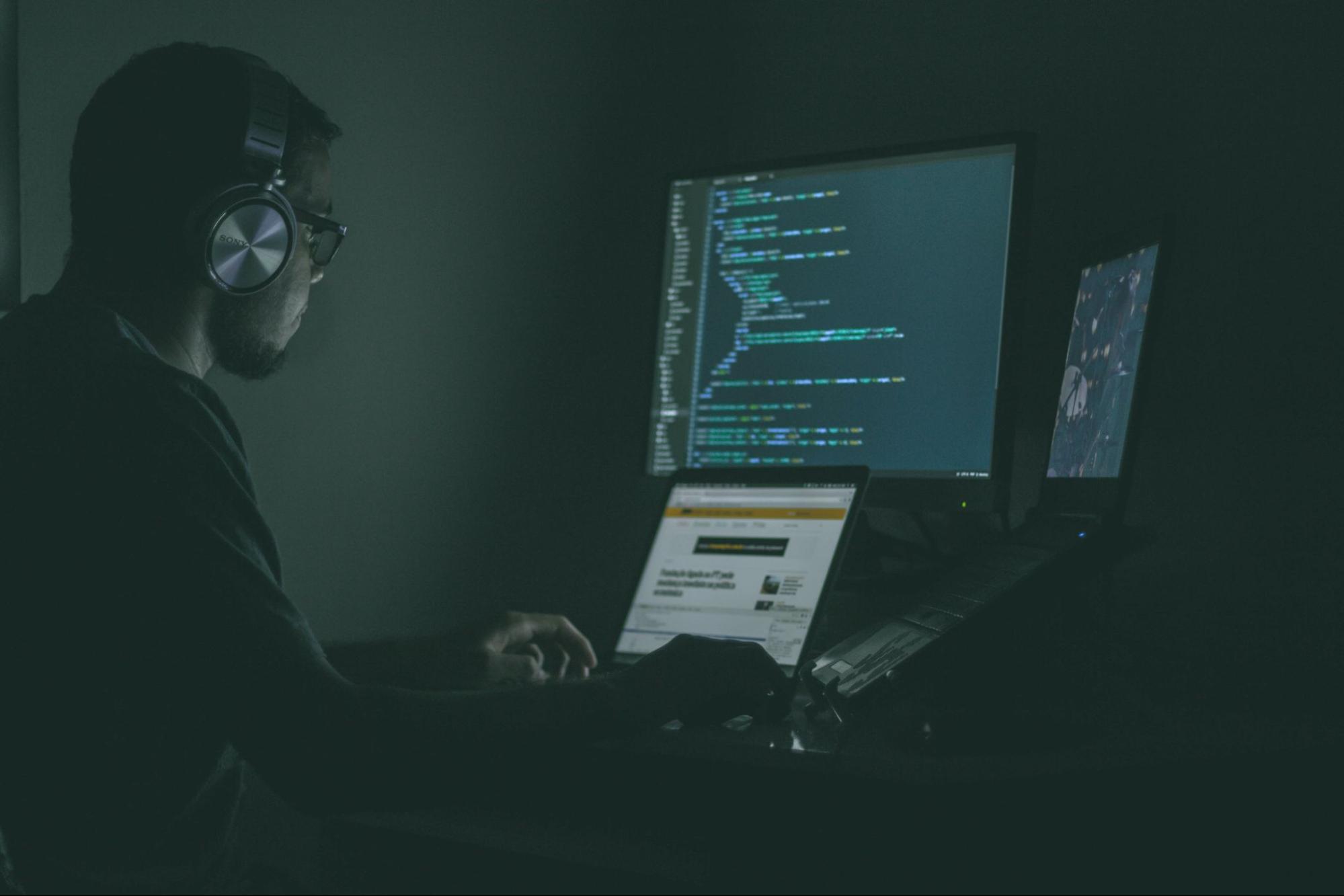 un hombre trabajando en código con auriculares