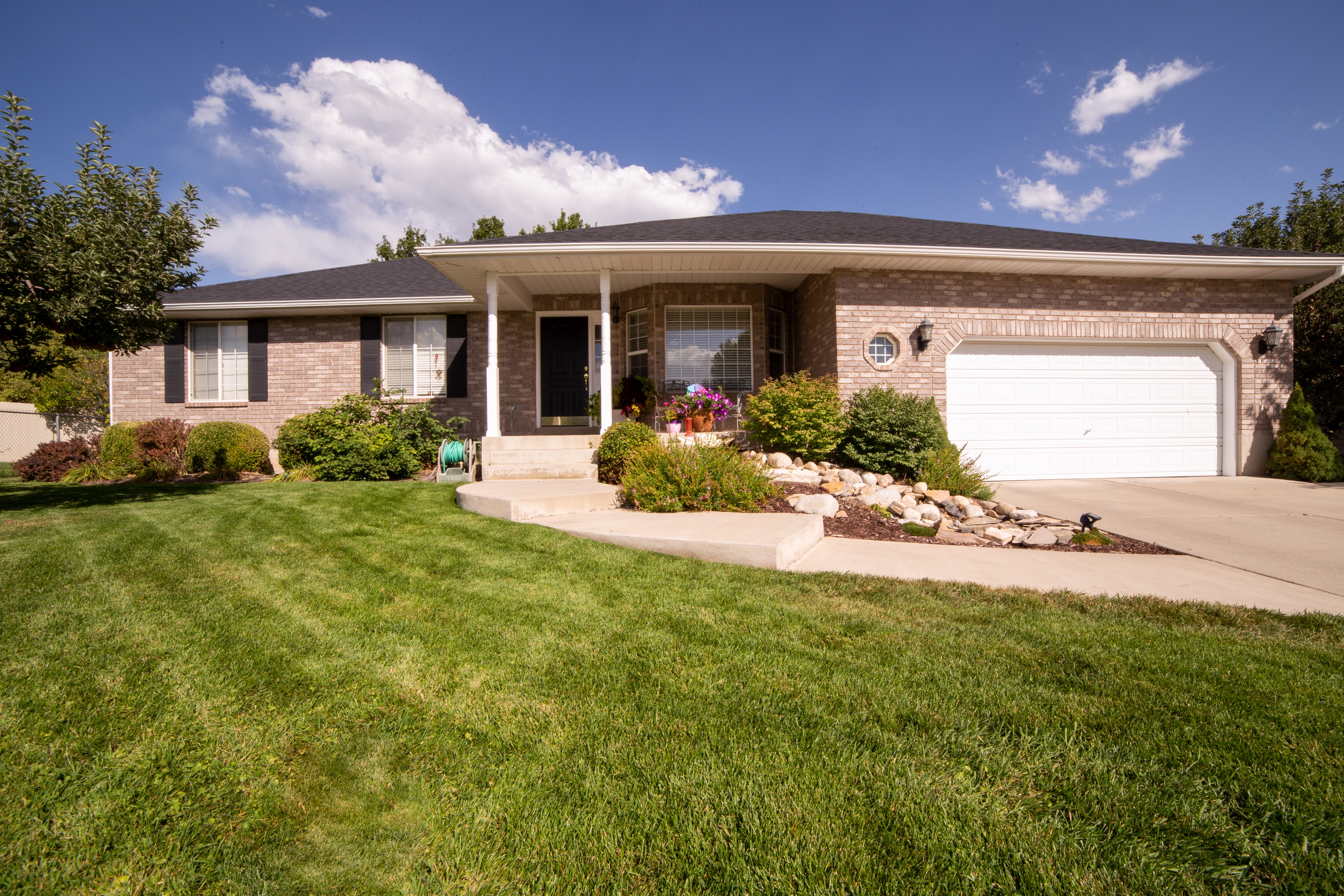 brick house with a manicured front lawn