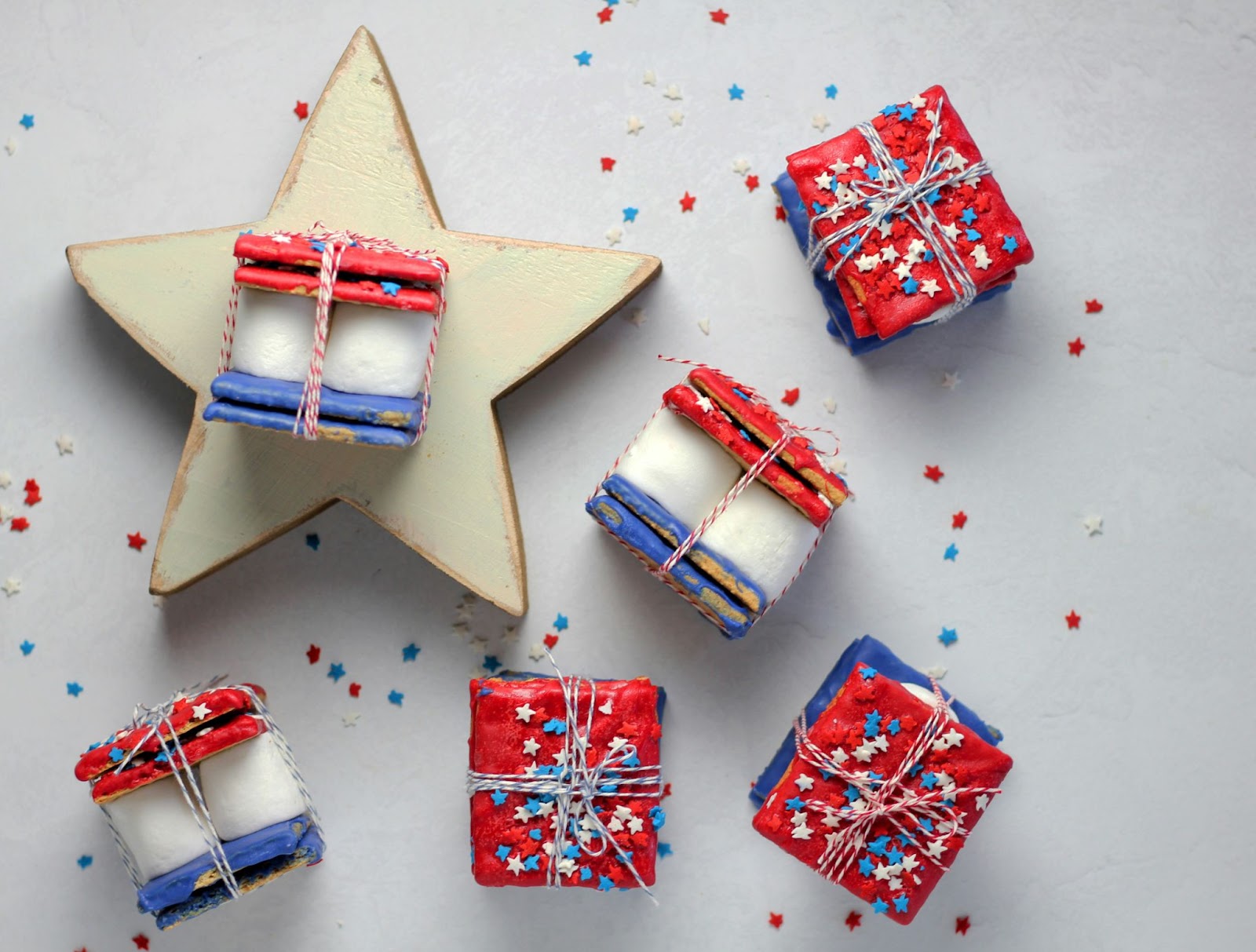 Red, white, and blue smores with star shaped sprinkles, wrapped in blue and white twine.