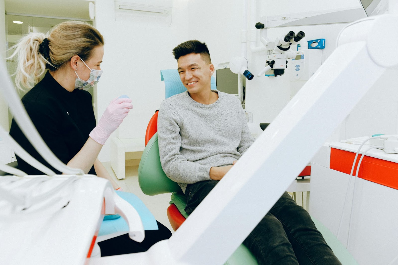 Man in dentist chair, comfortably speaking with his dentist.