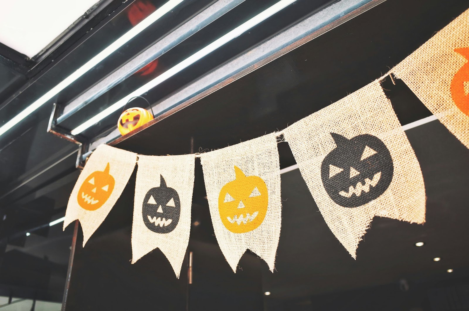 Tweed Halloween banner with alternating black and orange jack-o'-lanterns strung up in an industrial space.