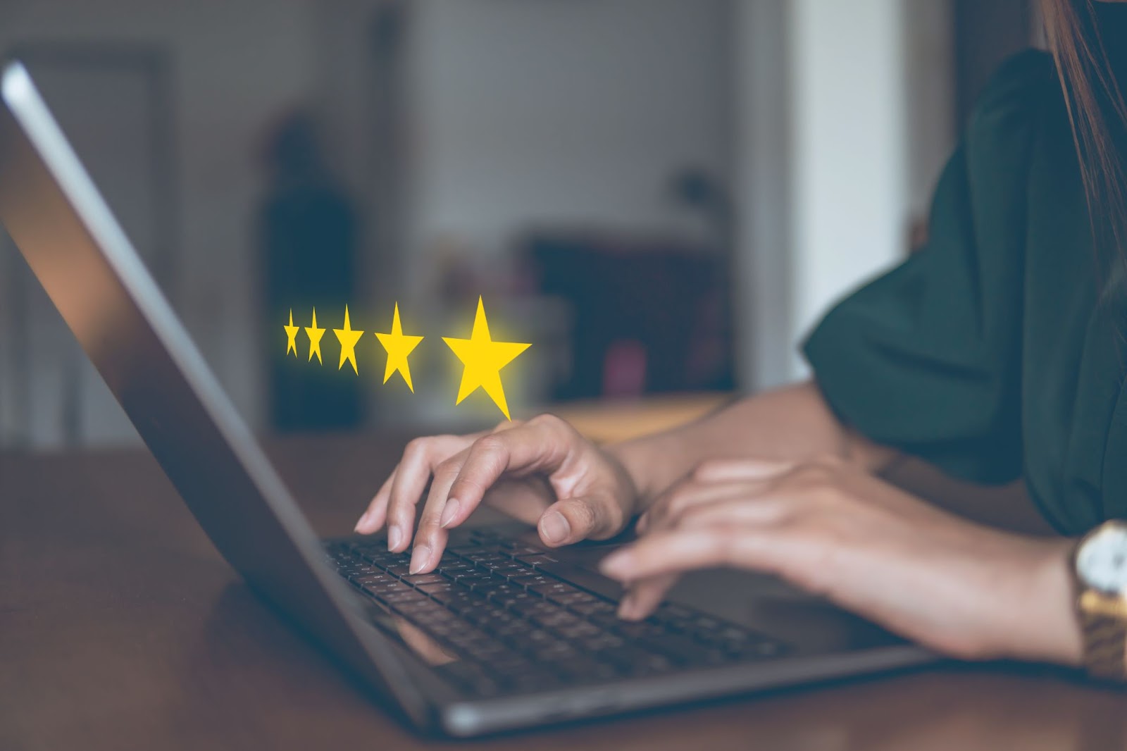 Woman in a home office with five gold stars superimposed over a laptop.