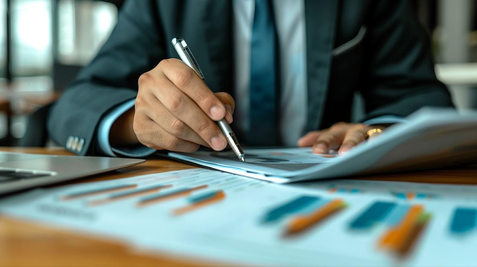 Person wearing a suit and taking notes at a desk in an office.