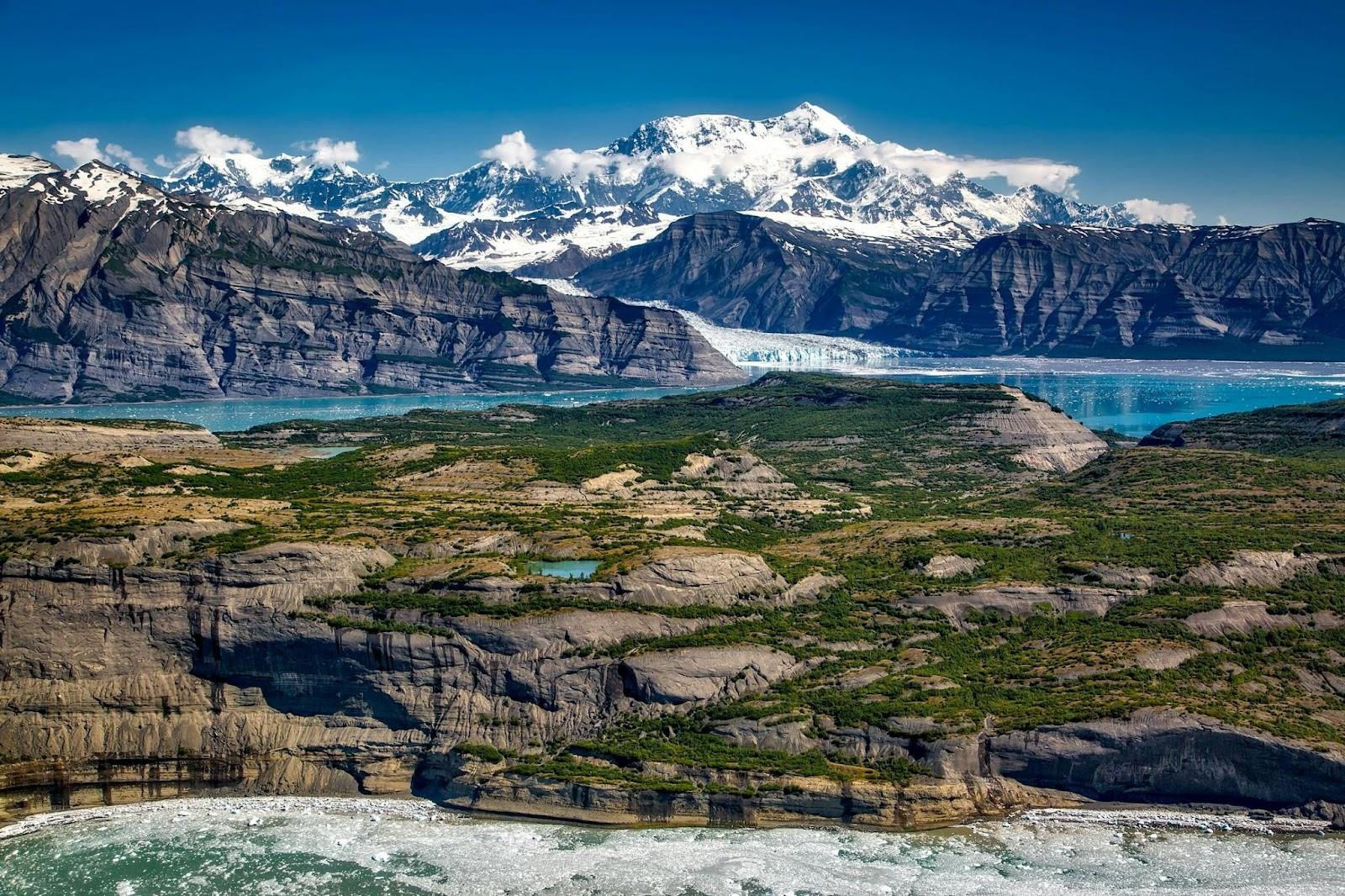landscape photo with hills, a lake, and mountains