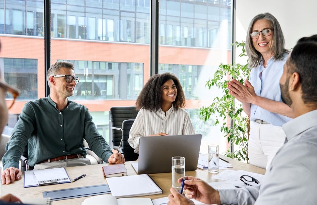 Team having a daytime meeting in a conference room with large windows.