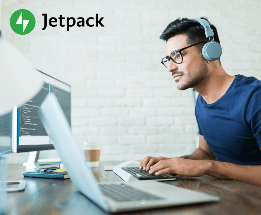 man wearing headphones working on a laptop