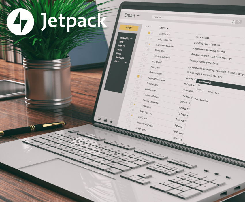 Email service open on a laptop on a desk next to a plant.